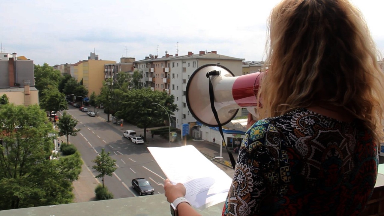 Sängerin mit Megaphon singt vom Kirchturm herunter